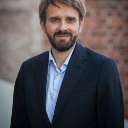 Portrett av smilende helseminister Vestre i blå skjorte og dressjakke