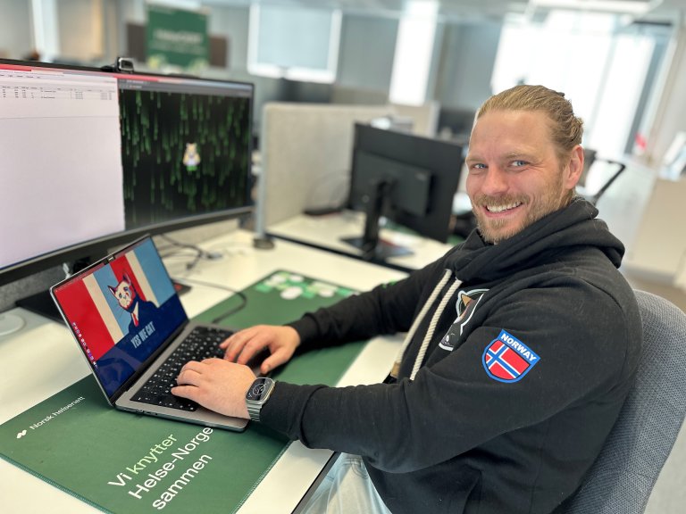 pen-tester/etisk hacker i Norsk helsenett, Jonas Bo Grimsgaard sitter foran noen PC-ene sine på kontoret.