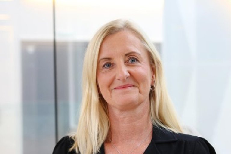 Smilende dame med lyst hår